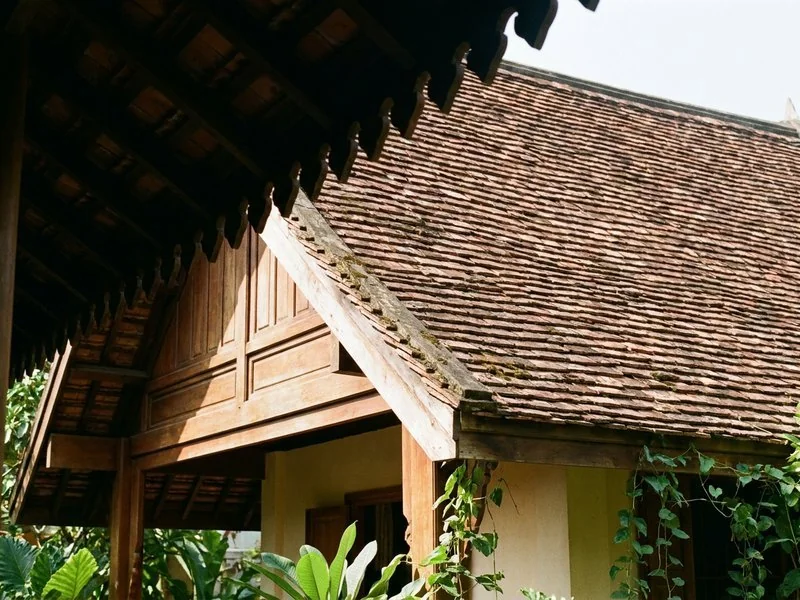 Mái ngói dốc lớn của nhà mái Thái vươn che hiên trong nắng hè