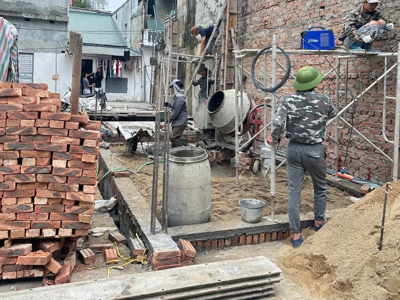 Gạch, cát và máy trộn tập kết gọn trong ngõ tại công trình nhà phố Sơn Đồng, Hoài Đức — Nhà Mộc thi công