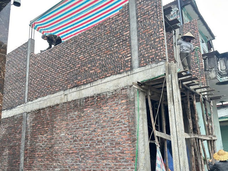 Nhà ống đang xây thô trong ngõ hẹp tại Sơn Đồng, Hoài Đức, có bạt che bên hàng xóm — Nhà Mộc thi công