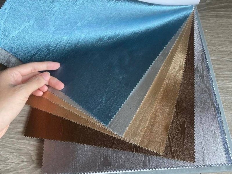 Xấp mẫu vải rèm nhiều tông xanh, nâu, be được trải ra để chọn màu