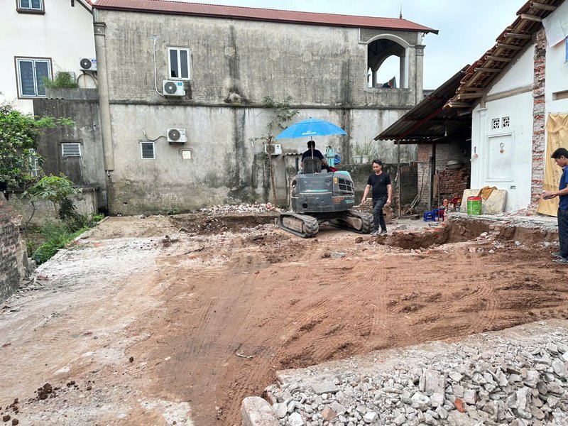 Máy xúc san mặt bằng trước khởi công tại công trình Cát Quế, Hoài Đức — Nhà Mộc thi công