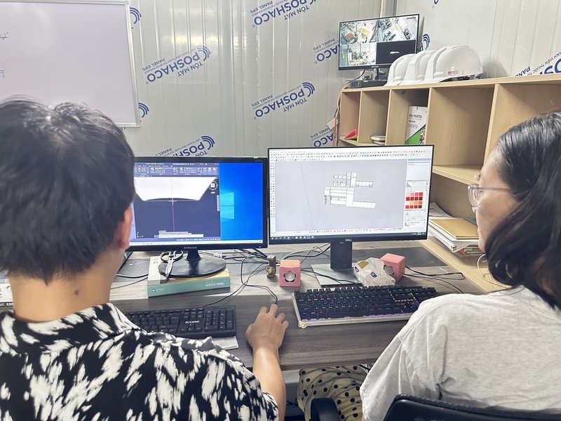 Hai kỹ sư Nhà Mộc soát bản vẽ mặt bằng trên hai màn hình tại văn phòng thiết kế